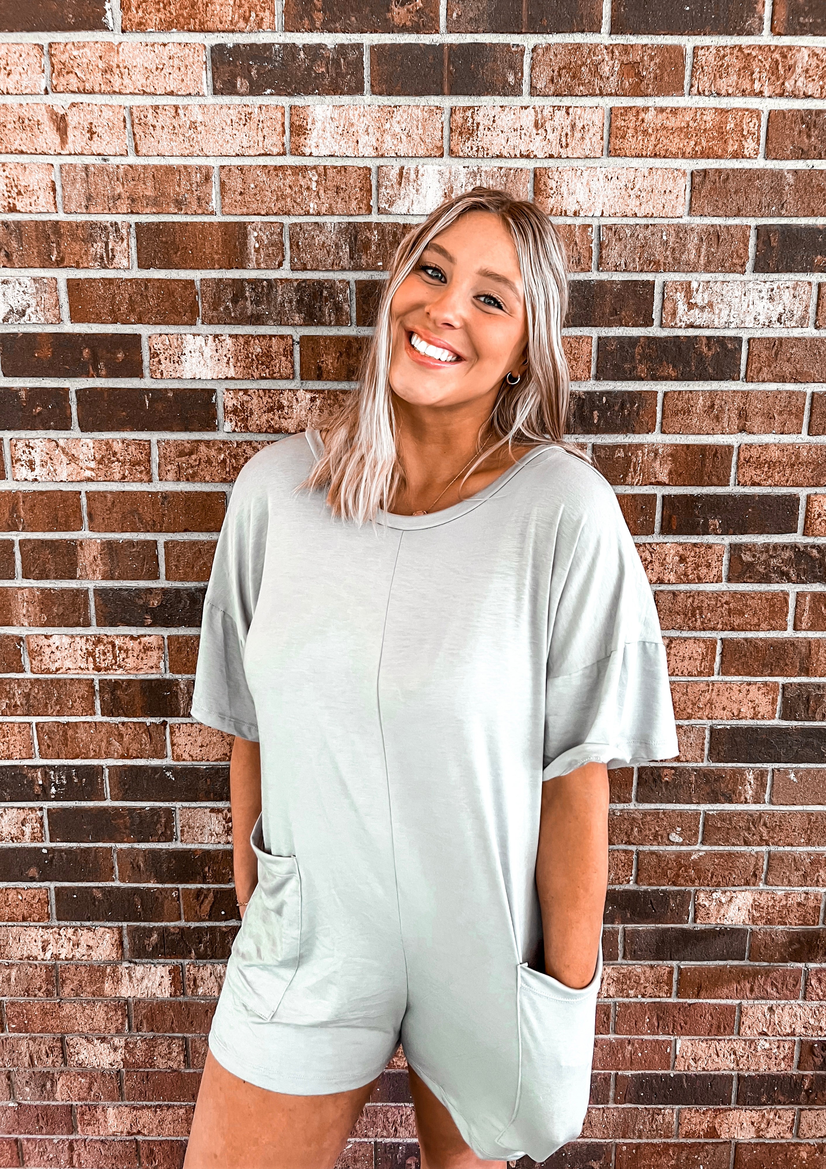 Indulge in relaxed elegance with this slate gray romper, boasting an oversized, flowy fit for maximum comfort and style. Featuring convenient front pockets and a chic v-neck detail at the back, this piece effortlessly merges fashion and functionality. Perfect for lounging at home or stepping out with a touch of effortless sophistication