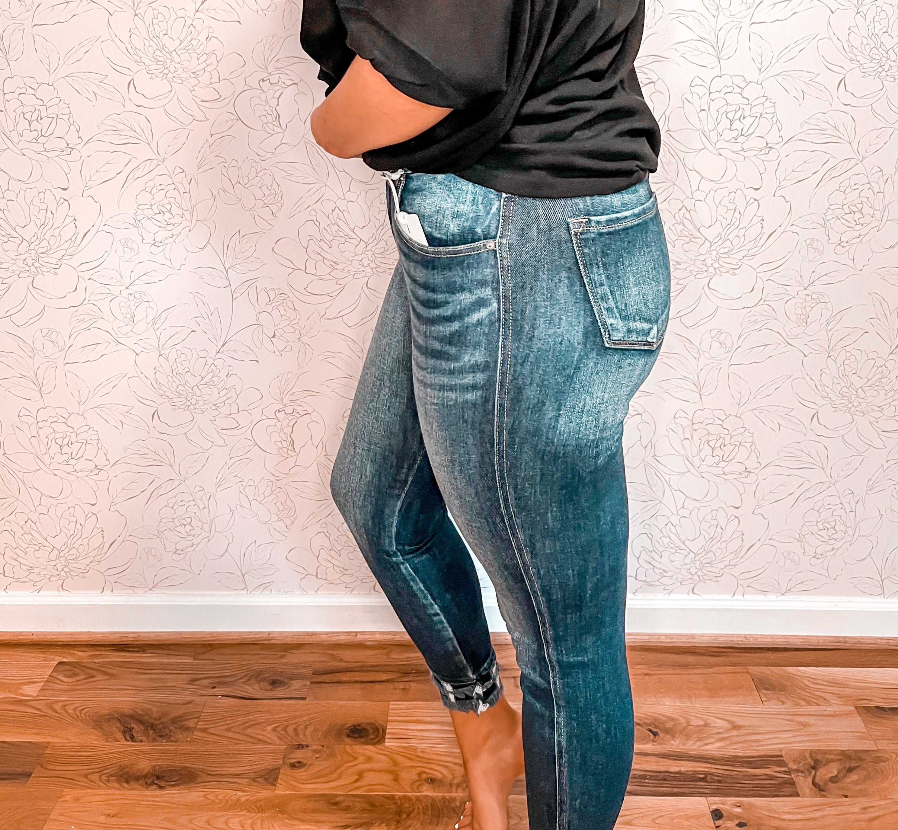 KanCan high-rise skinny jeans in a dark wash, made from a stretchy denim material that ensures both comfort and a sleek silhouette. The standout feature is the unique double frayed hem detail at the bottom, adding a playful and cute twist to the classic skinny jean design. The dark wash and stylish hem make these jeans versatile for both casual and dressier occasions